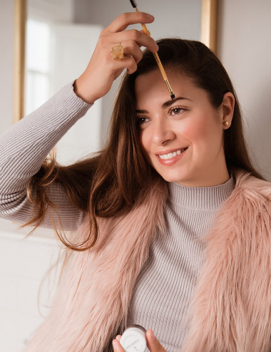 Mujer usando brocha dual para cejas de bambu ecologico