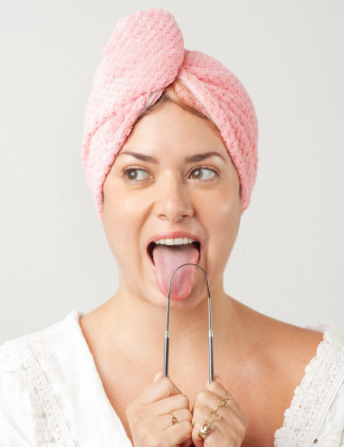 Mujer usando limpiador de lengua de acero inxodibable