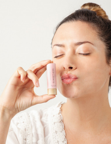 Mujer usando balsamo natural y organico humectante para labios Sunset Kiss