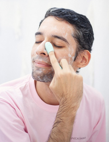 Hombre usando gel limpiador jabon liquido natural y organico suave con dedo exfoliante facial menta
