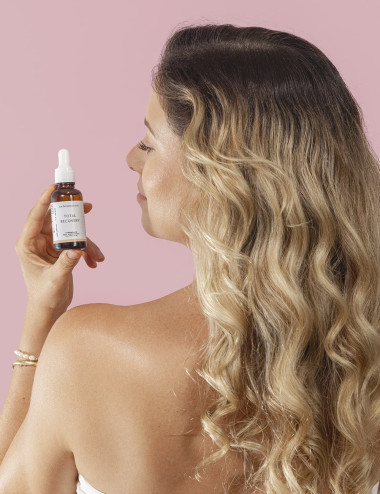 Mujer usando aceite fortalecedor para cabello con jojoba argan y romero