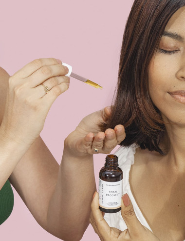 Mujer usando aceite fortalecedor para cabello con jojoba argan y romero